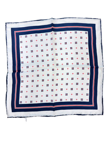 A square white scarf with a navy blue border and a repeating red and navy geometric pattern, laid flat on a white surface.